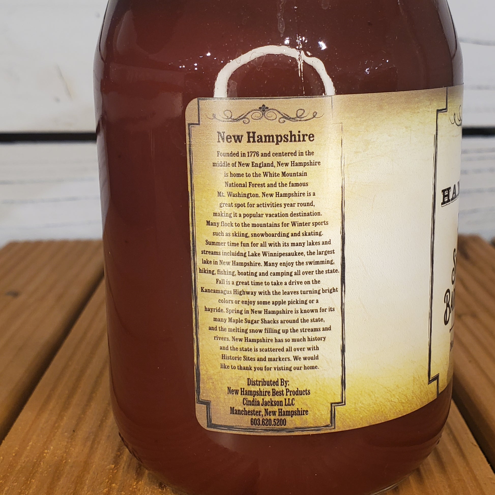 Bottle of New Hampshire maple syrup with a label on a wooden surface