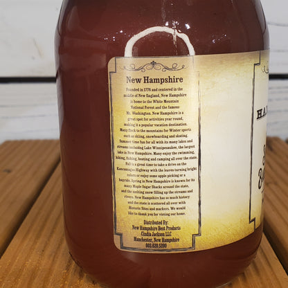 Bottle of New Hampshire maple syrup with a label on a wooden surface
