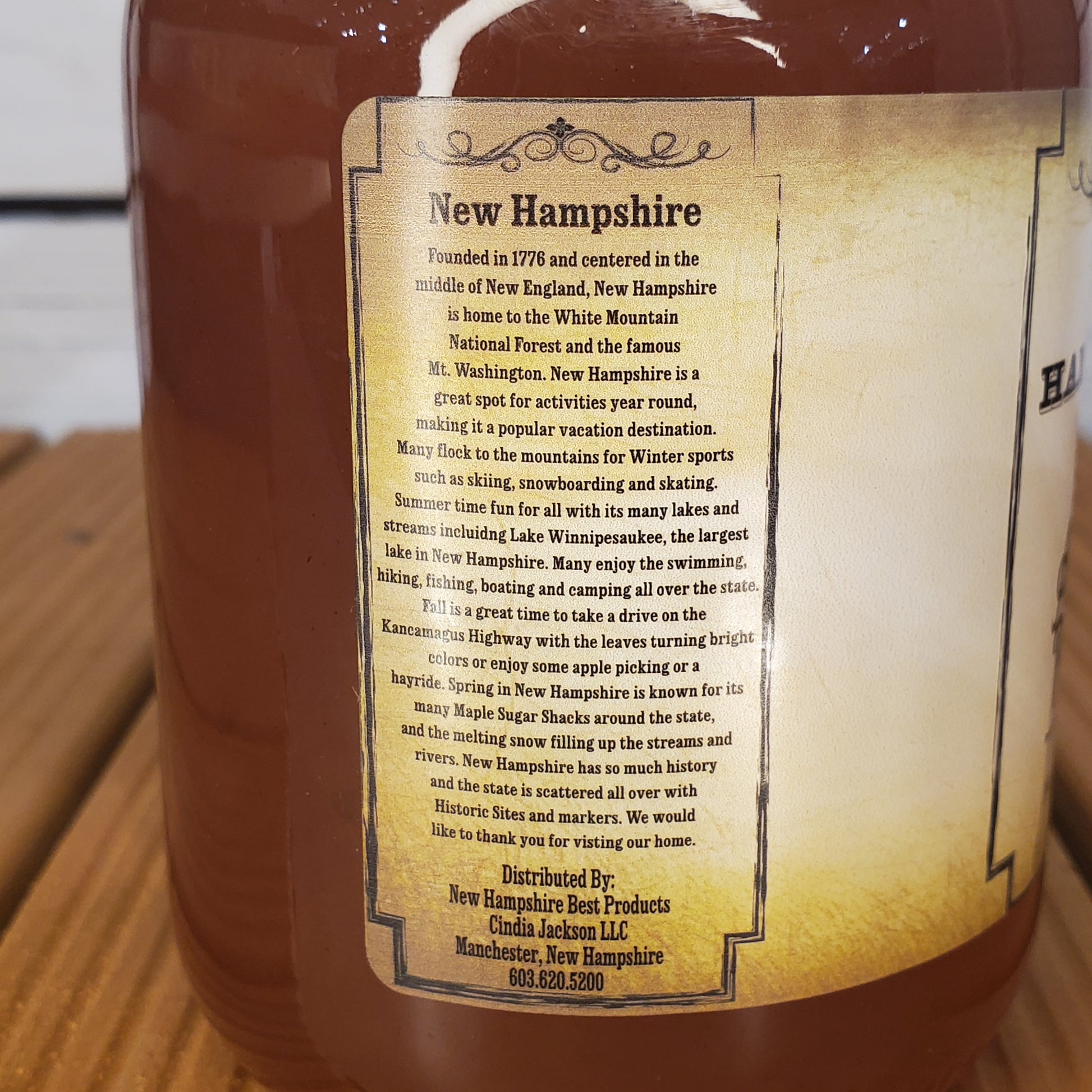 Bottle with a label detailing New Hampshire history on a wooden surface