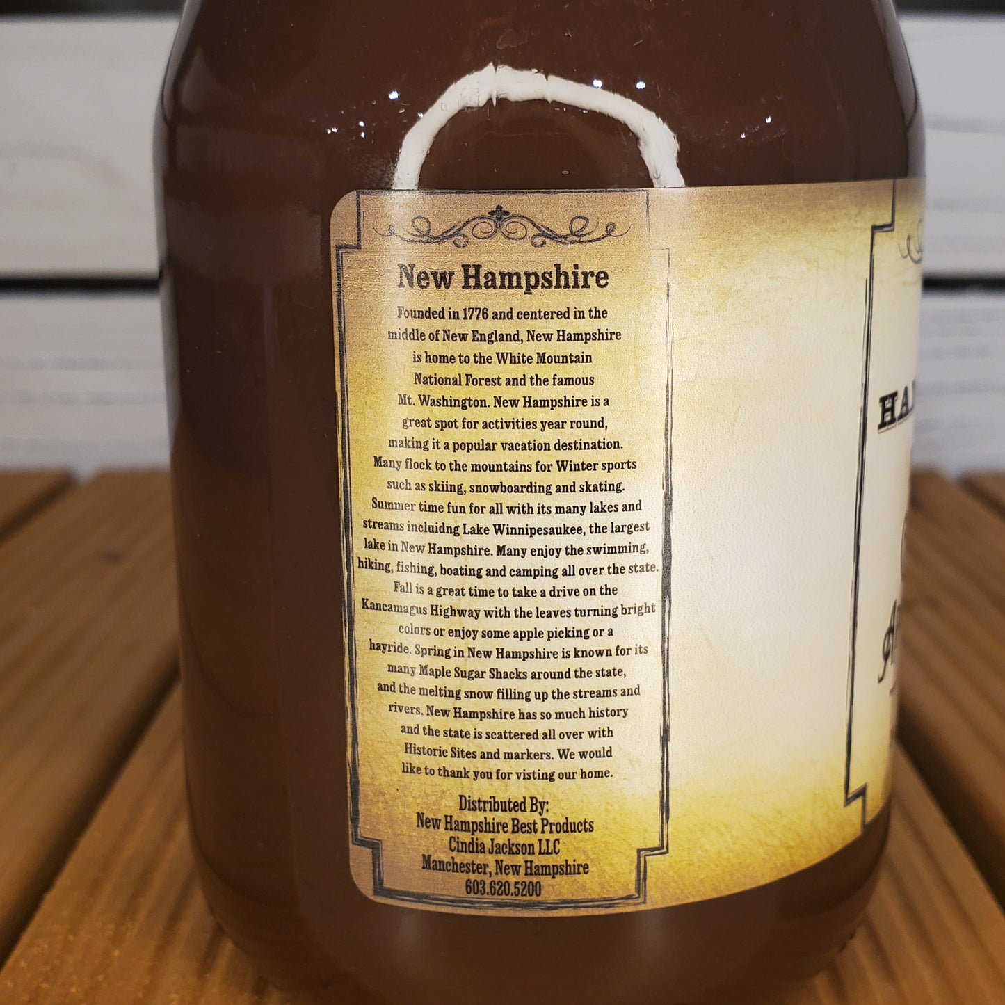 Bottle of New Hampshire maple syrup with a label on a wooden surface