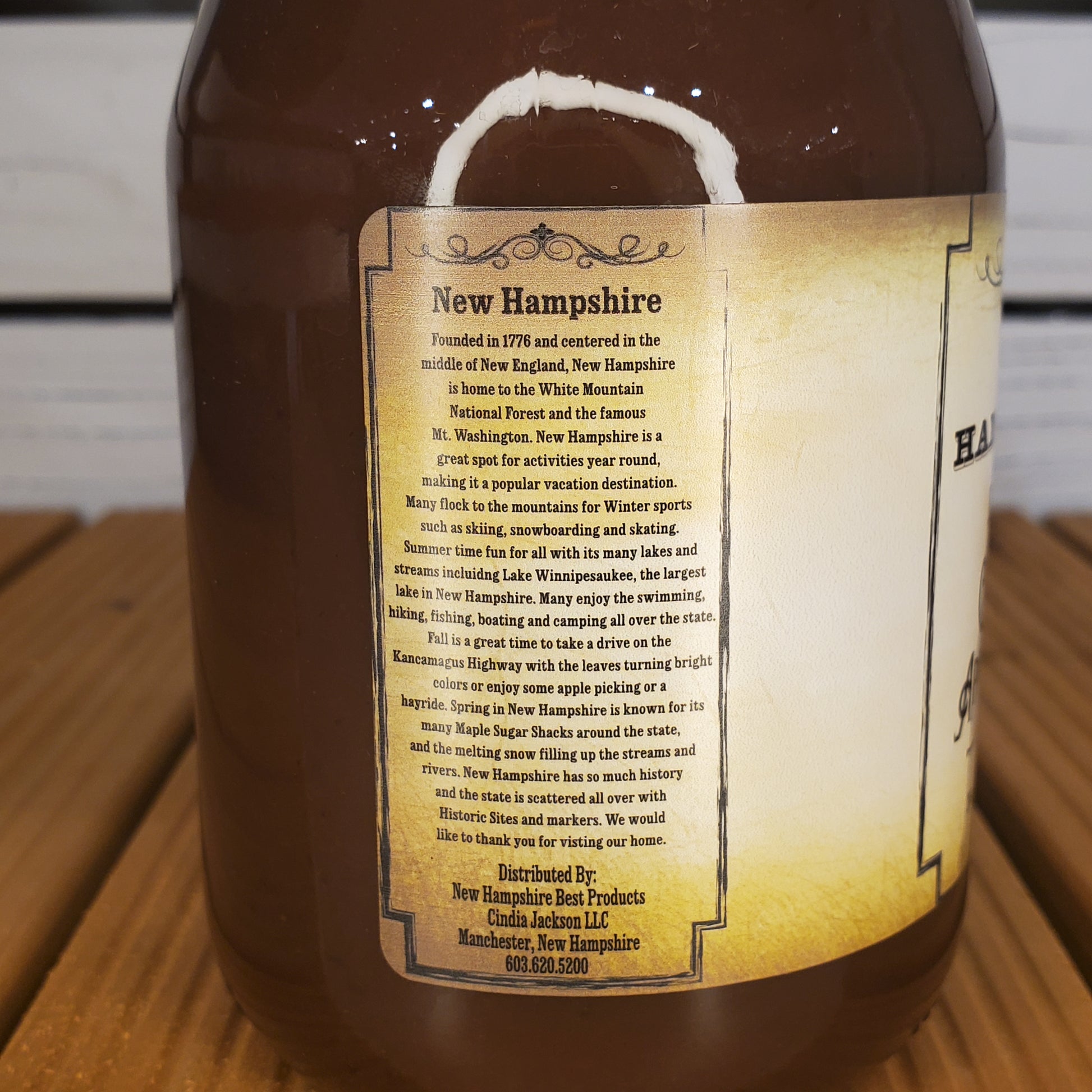 Bottle of New Hampshire maple syrup with a label on a wooden surface