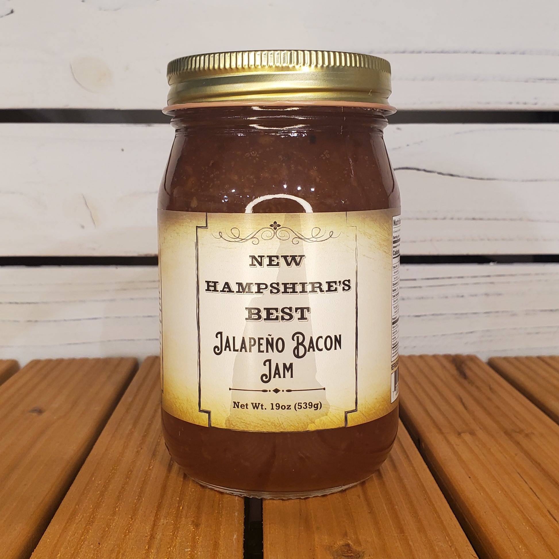 Jar of New Hampshire's Best Jalapeno Bacon Jam on a wooden surface