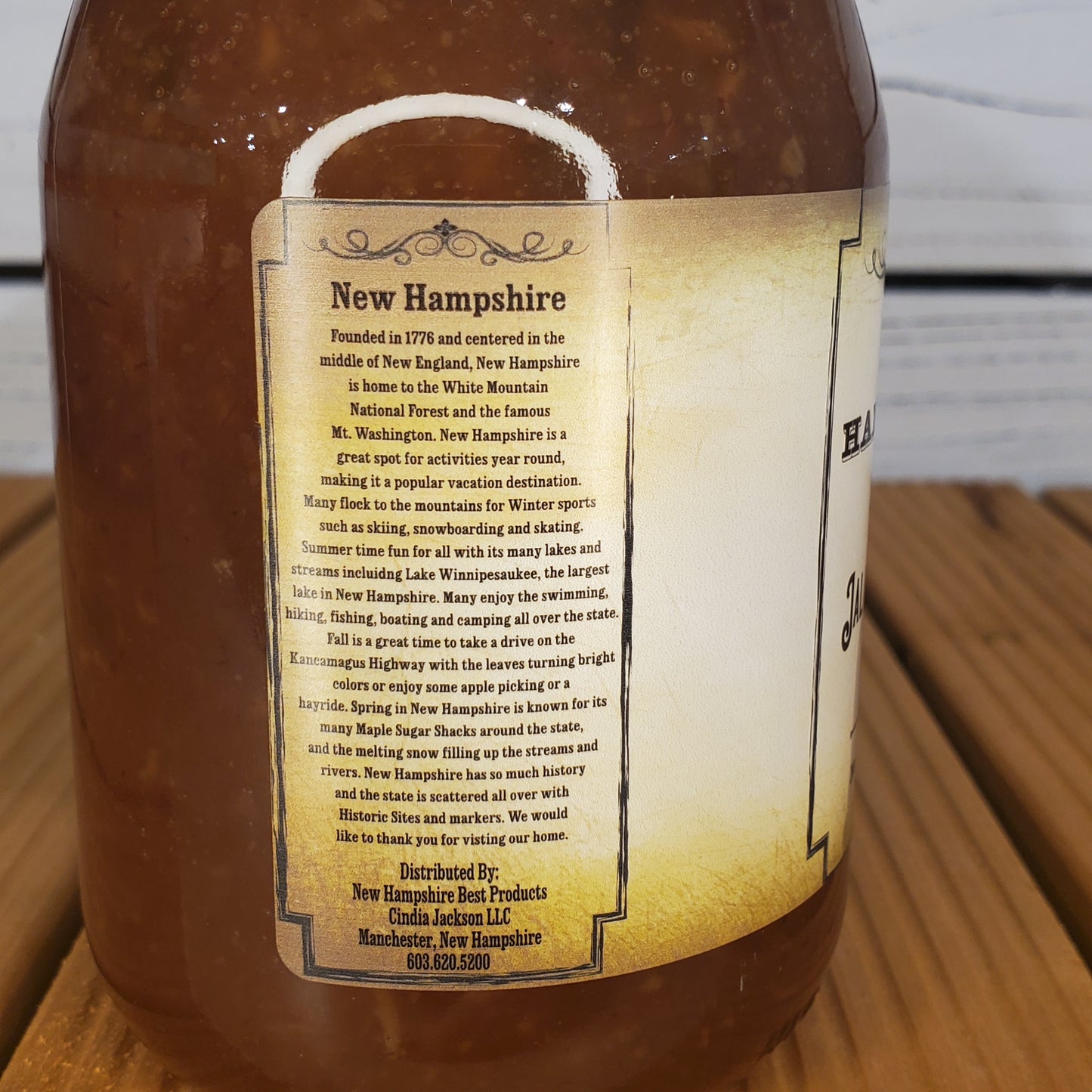 Bottle of New Hampshire maple syrup with a label on a wooden surface