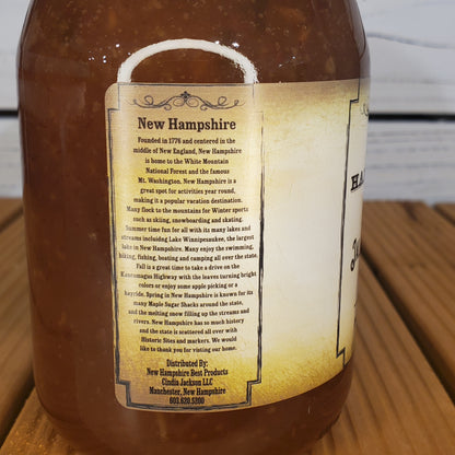 Bottle of New Hampshire maple syrup with a label on a wooden surface