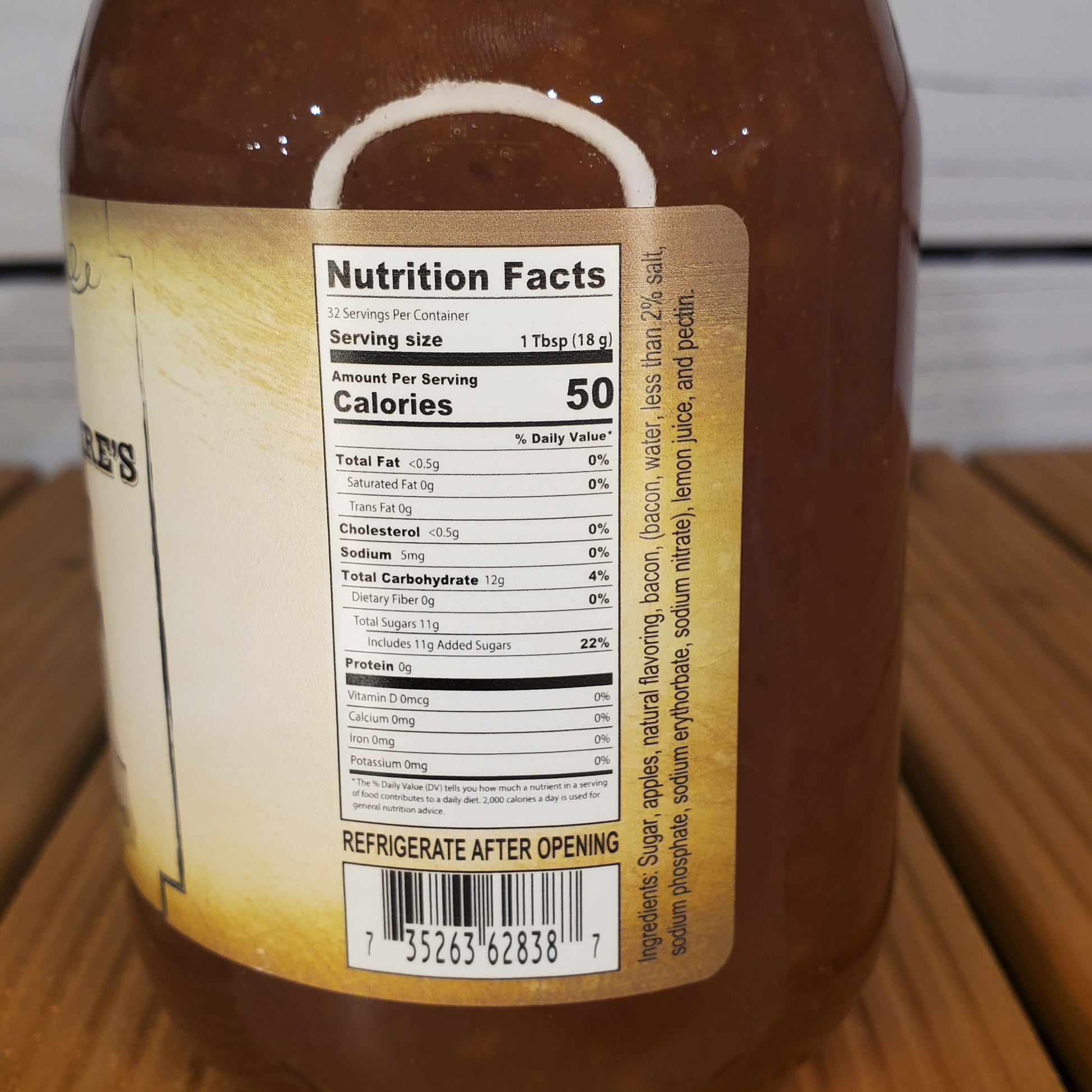 Nutrition facts label on a jar of sauce with a wooden surface in the background