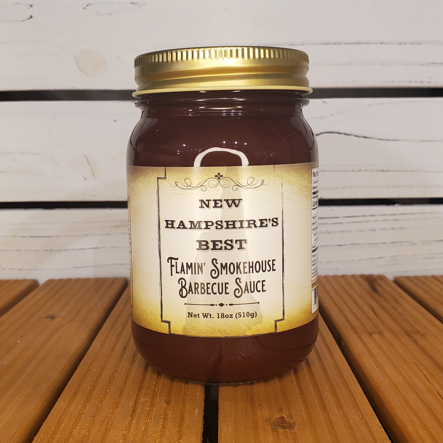 Jar of Flaming Smokehouse Barbecue Sauce on a wooden surface