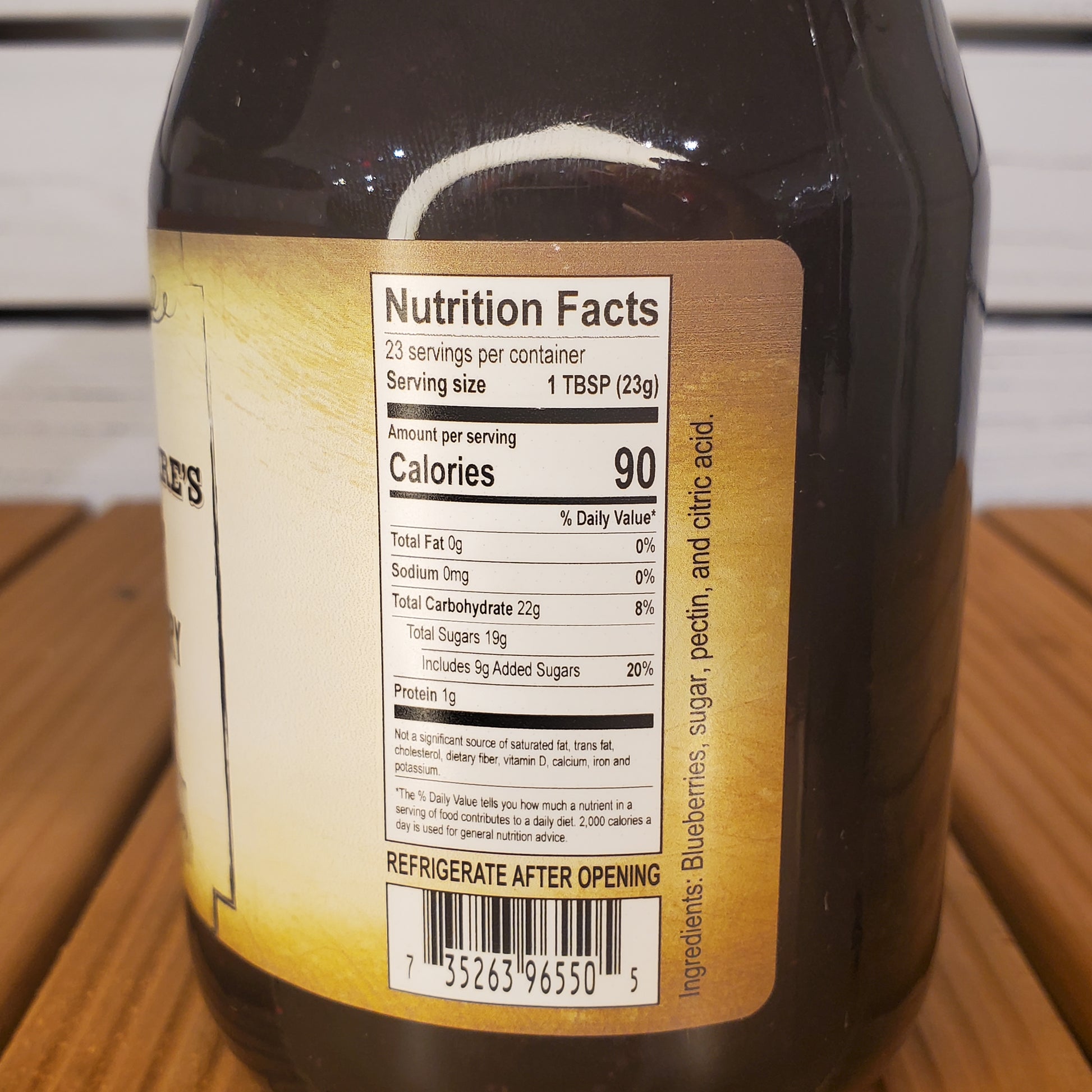 Close-up of a bottle label with nutrition facts on a wooden surface