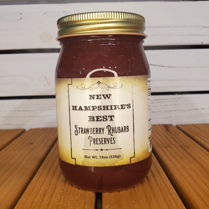 Jar of New Hampshire's Best Strawberry Rhubarb Preserves on a wooden surface with a white background