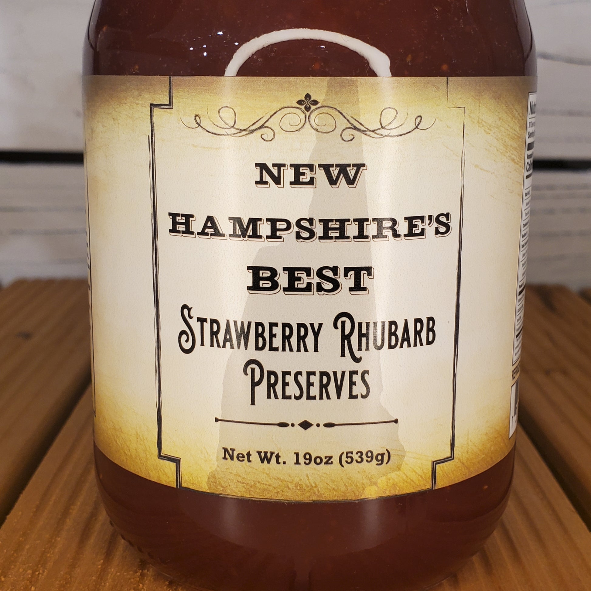 Jar of New Hampshire's Best Strawberry Rhubarb Preserves on a wooden surface