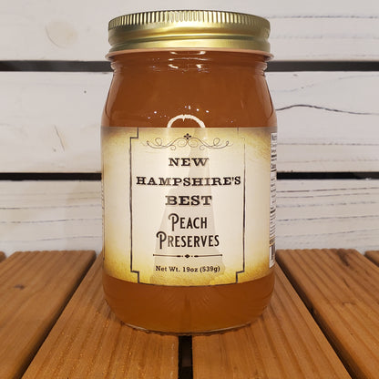 Jar of New Hampshire's Best Peach Preserves on a wooden surface
