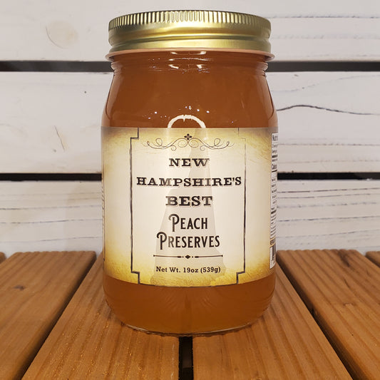 Jar of New Hampshire's Best Peach Preserves on a wooden surface