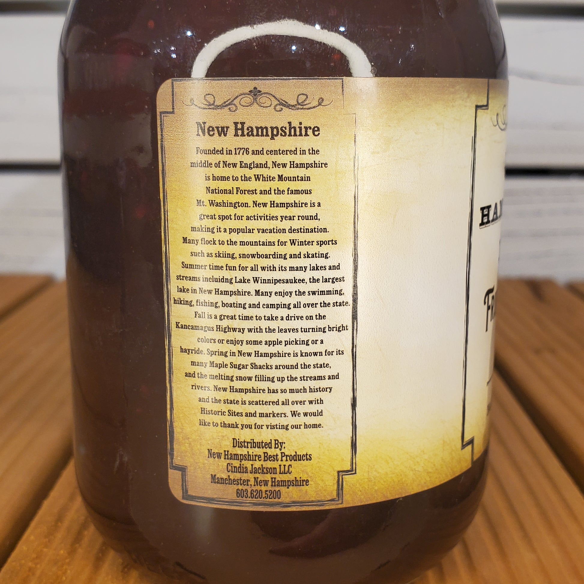 Bottle of New Hampshire maple syrup with a label on a wooden surface