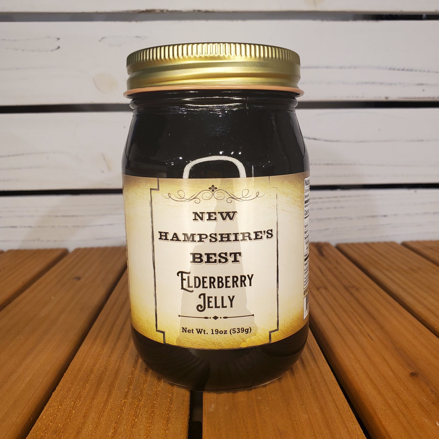 Jar of New Hampshire's Best Elderberry Jelly on a wooden surface