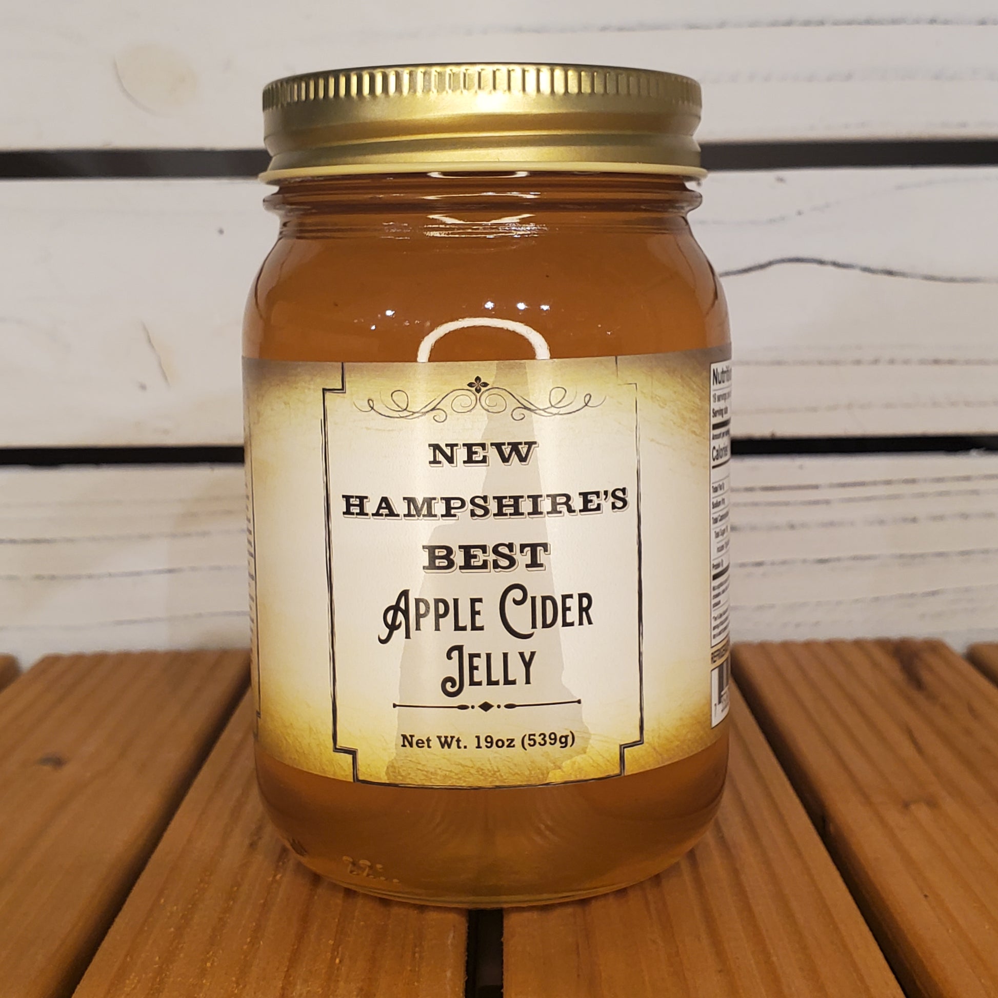 Jar of New Hampshire's Best Apple Cider Jelly on a wooden surface
