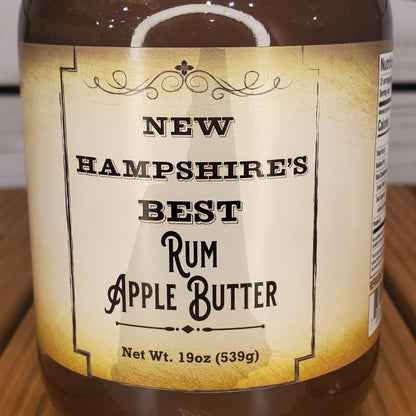 Jar of New Hampshire's Best Rum Apple Butter with label on a wooden surface