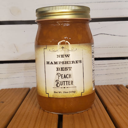 Jar of New Hampshire's Best Peach Butter on a wooden surface