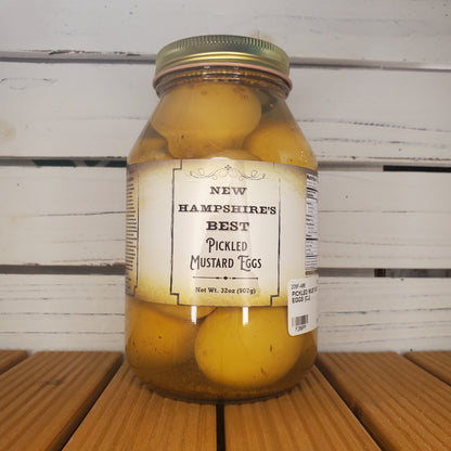 Jar of pickled mustard cobs with a label on a wooden surface