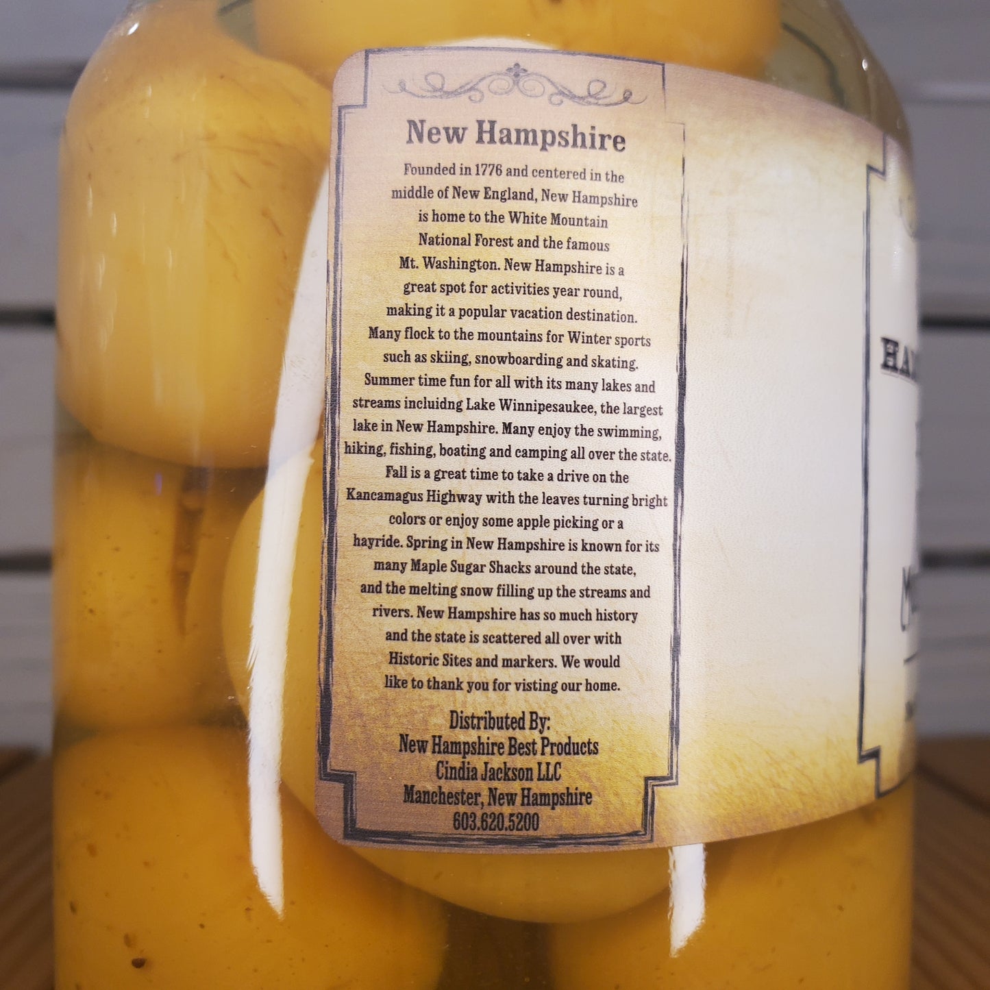 Yellow cheese wheels with a New Hampshire label on a wooden surface