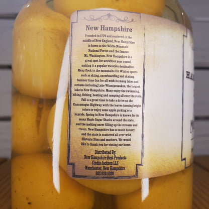 Yellow cheese wheels with a New Hampshire label on a wooden surface