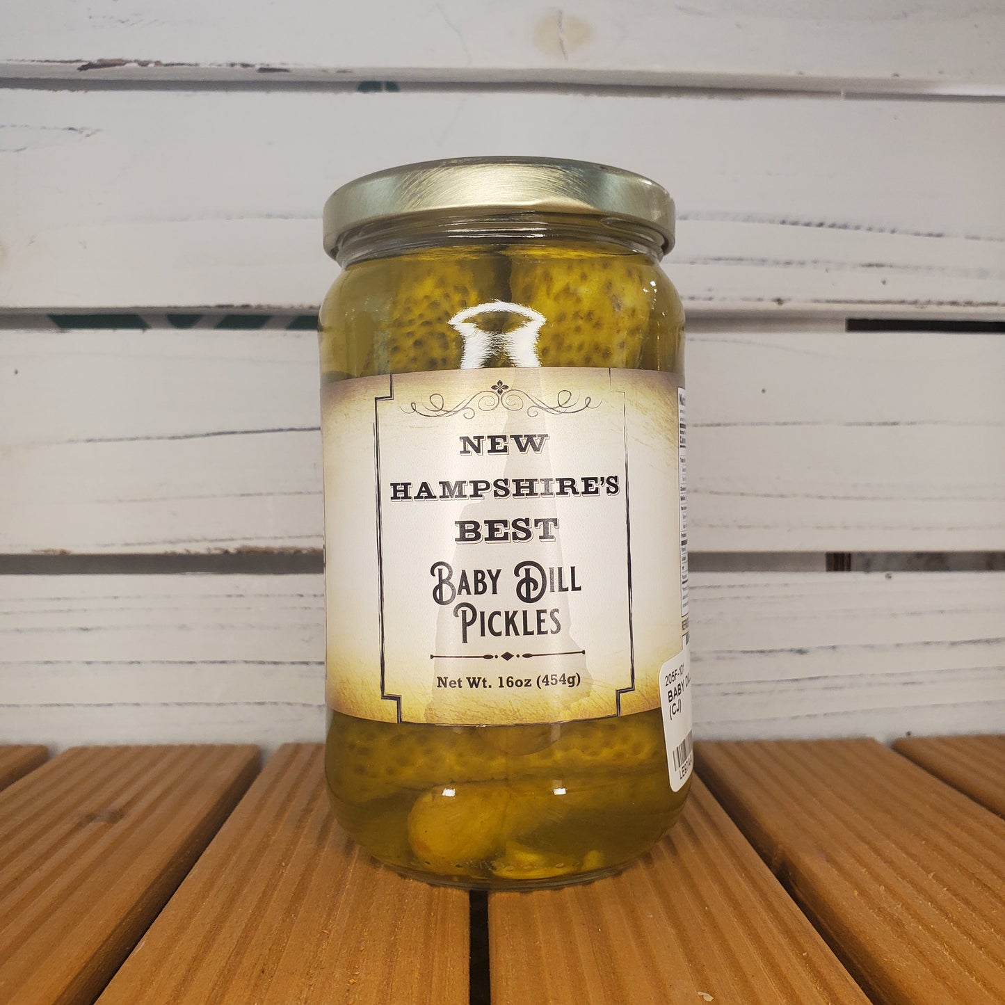 Jar of New Hampshire's Best Baby Dill Pickles on a wooden surface
