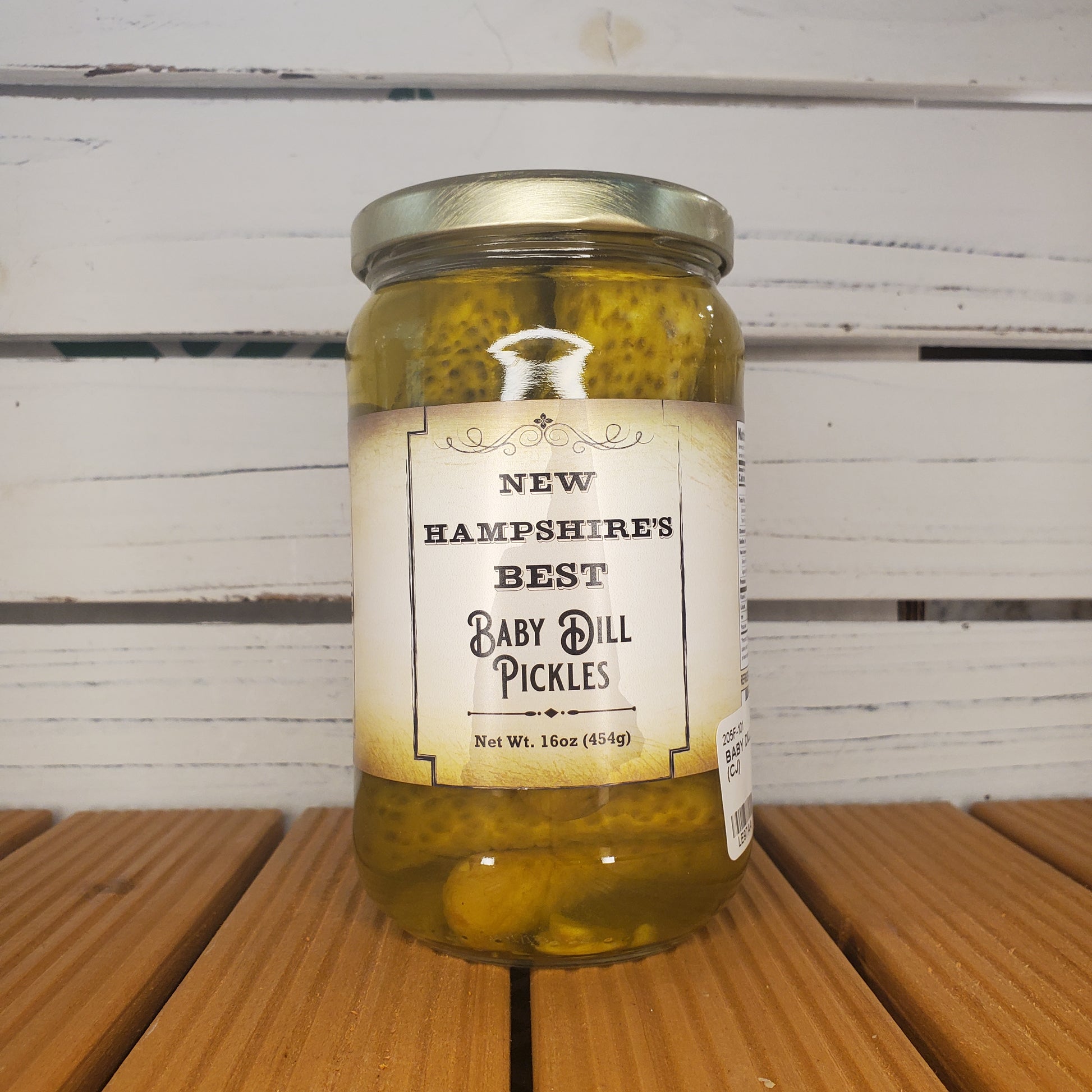 Jar of New Hampshire's Best Baby Dill Pickles on a wooden surface