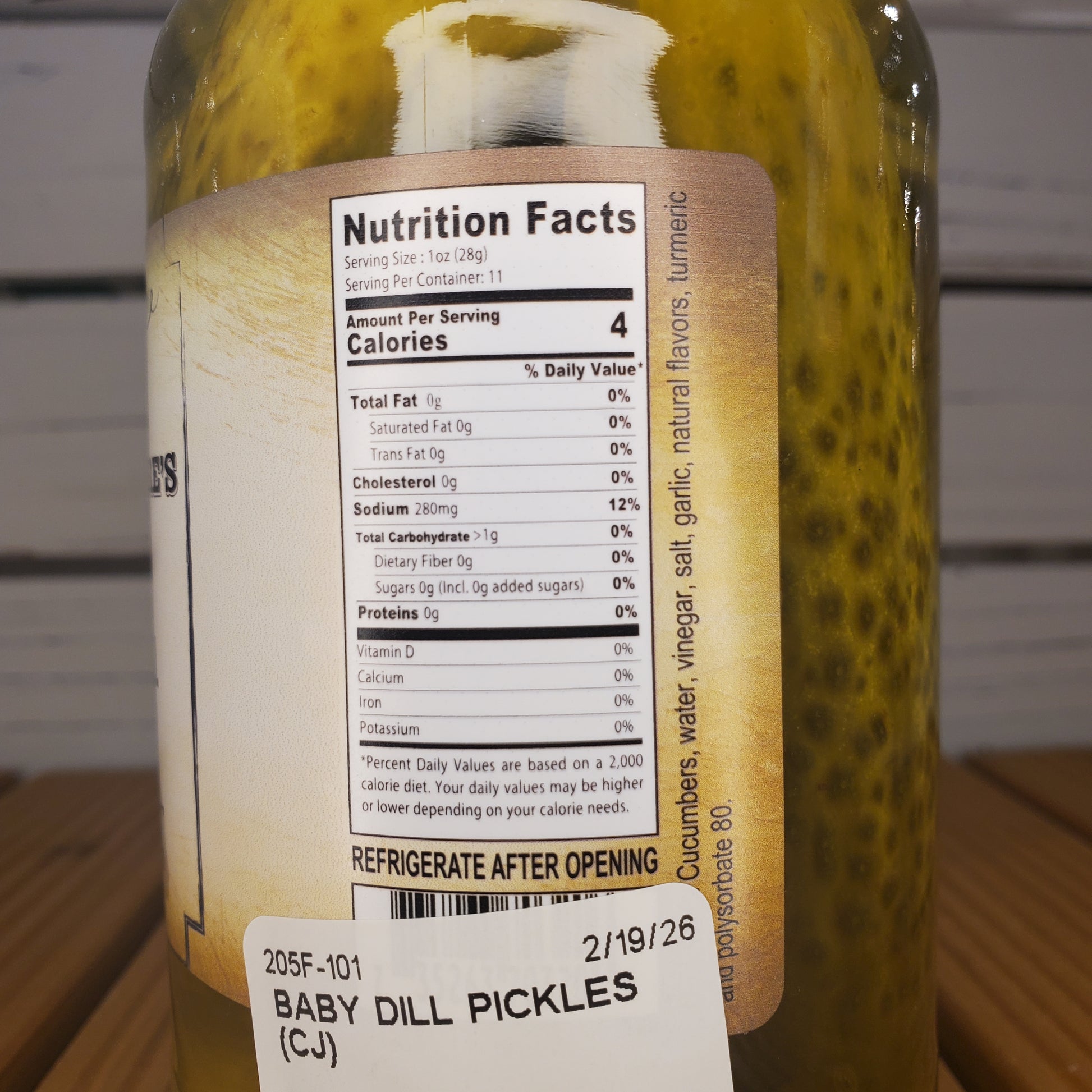 Close-up of a pickle with a label showing nutrition facts and storage instructions.