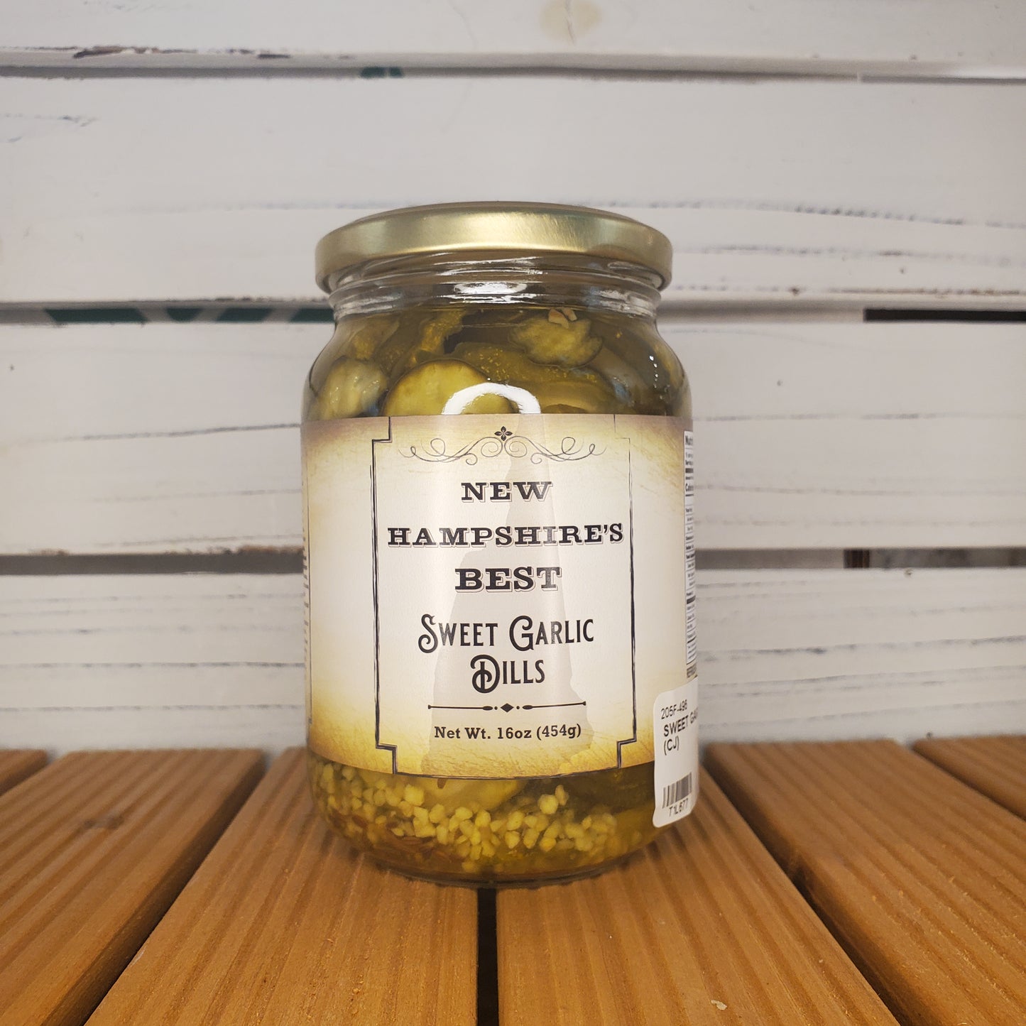 Jar of New Hampshire's Best Sweet Garlic Dills on a wooden surface with a white background