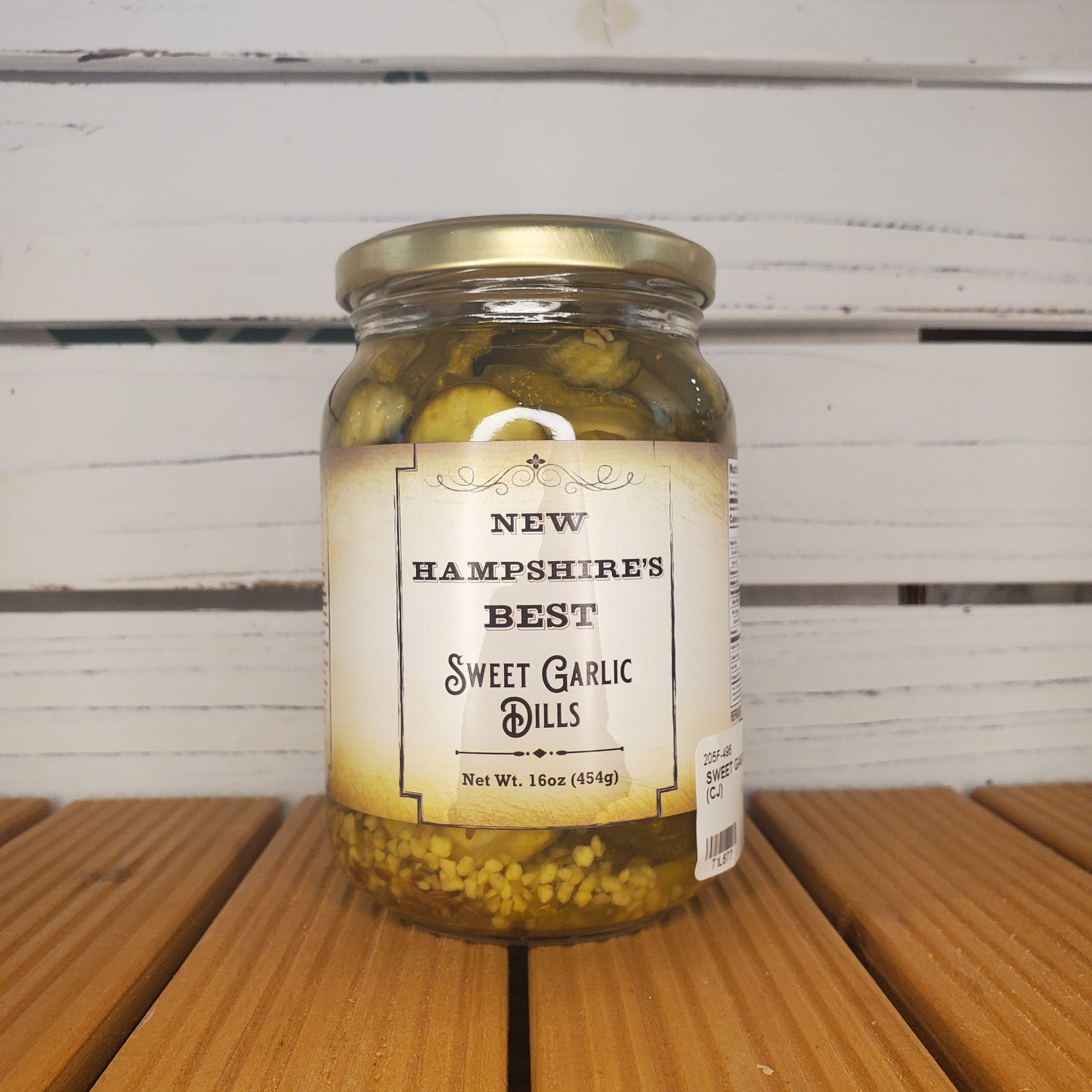 Jar of New Hampshire's Best Sweet Garlic Dills on a wooden surface with a white background