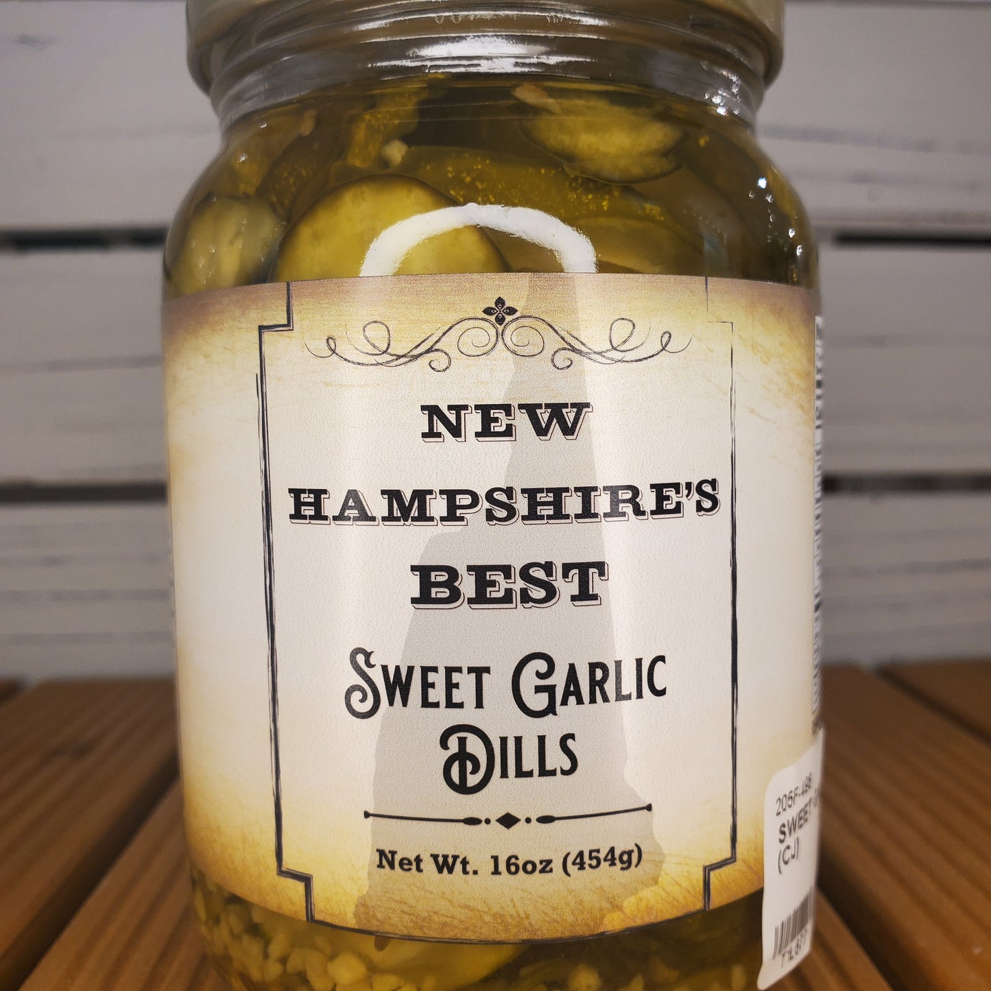 Jar of New Hampshire's Best Sweet Garlic Dills on a wooden surface