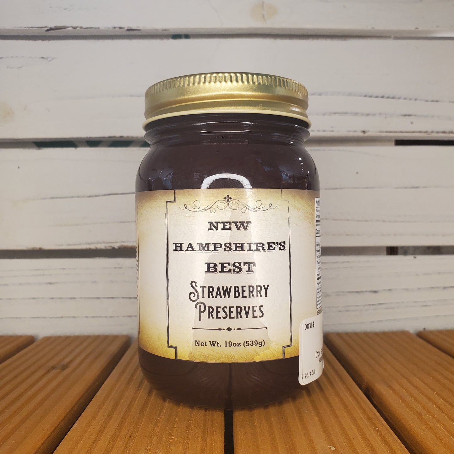 Jar of New Hampshire Best Strawberry Preserves on a wooden surface
