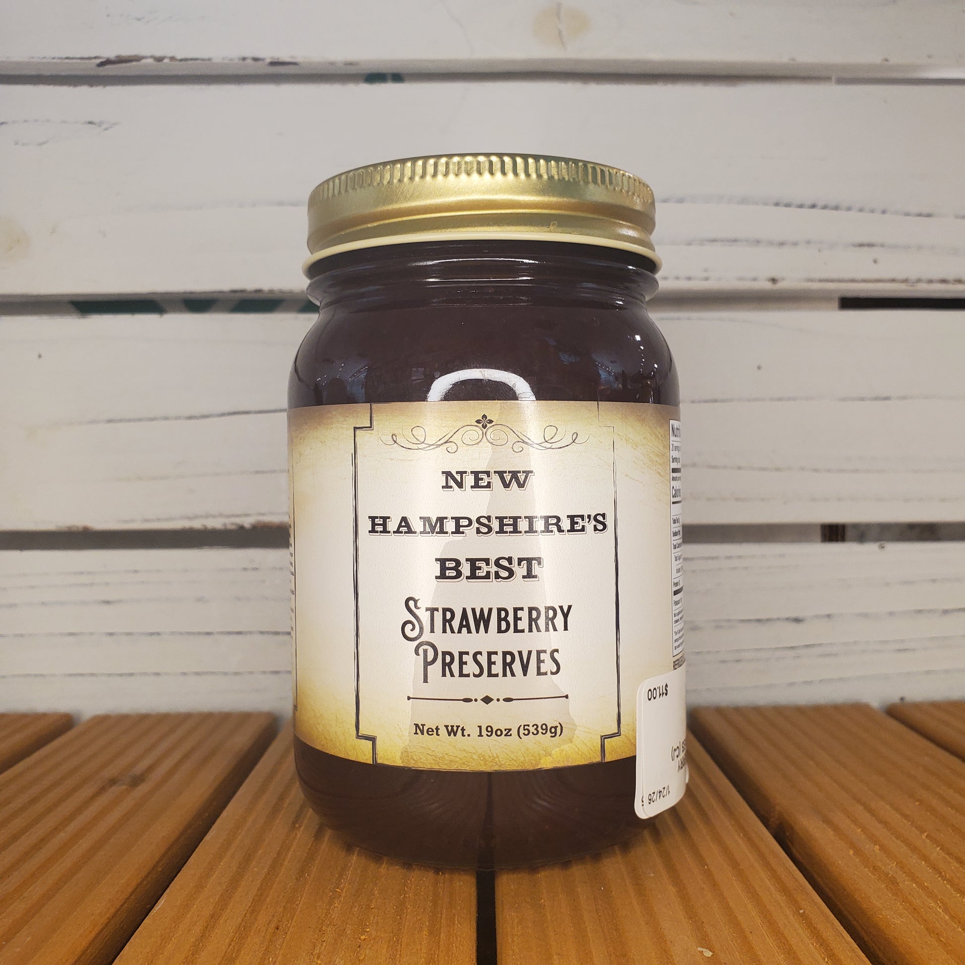 Jar of New Hampshire Best Strawberry Preserves on a wooden surface