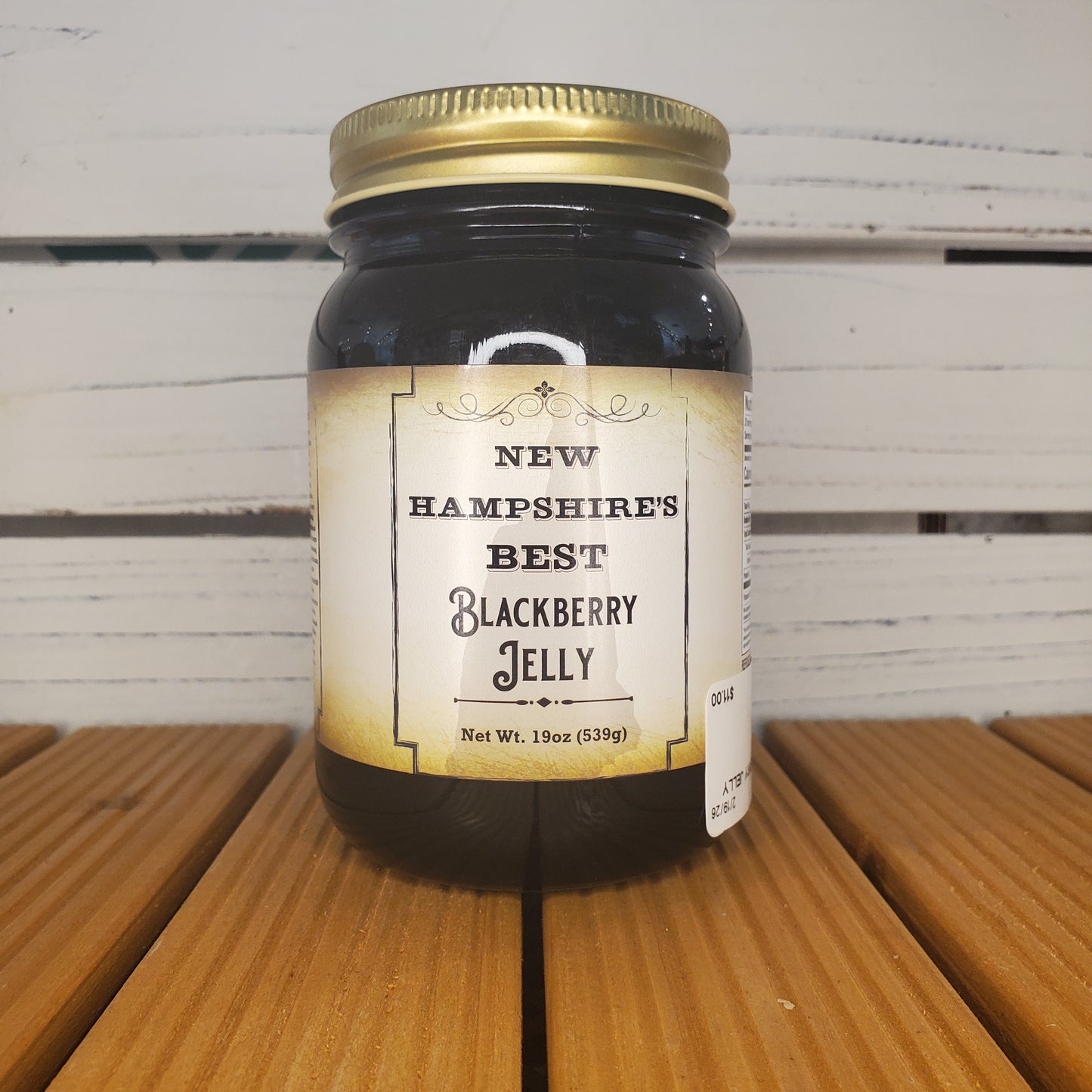 Jar of New Hampshire's Best Blackberry Jelly on a wooden surface