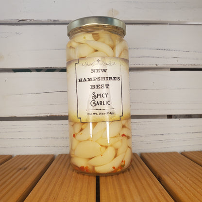Jar of spicy garlic on a wooden surface