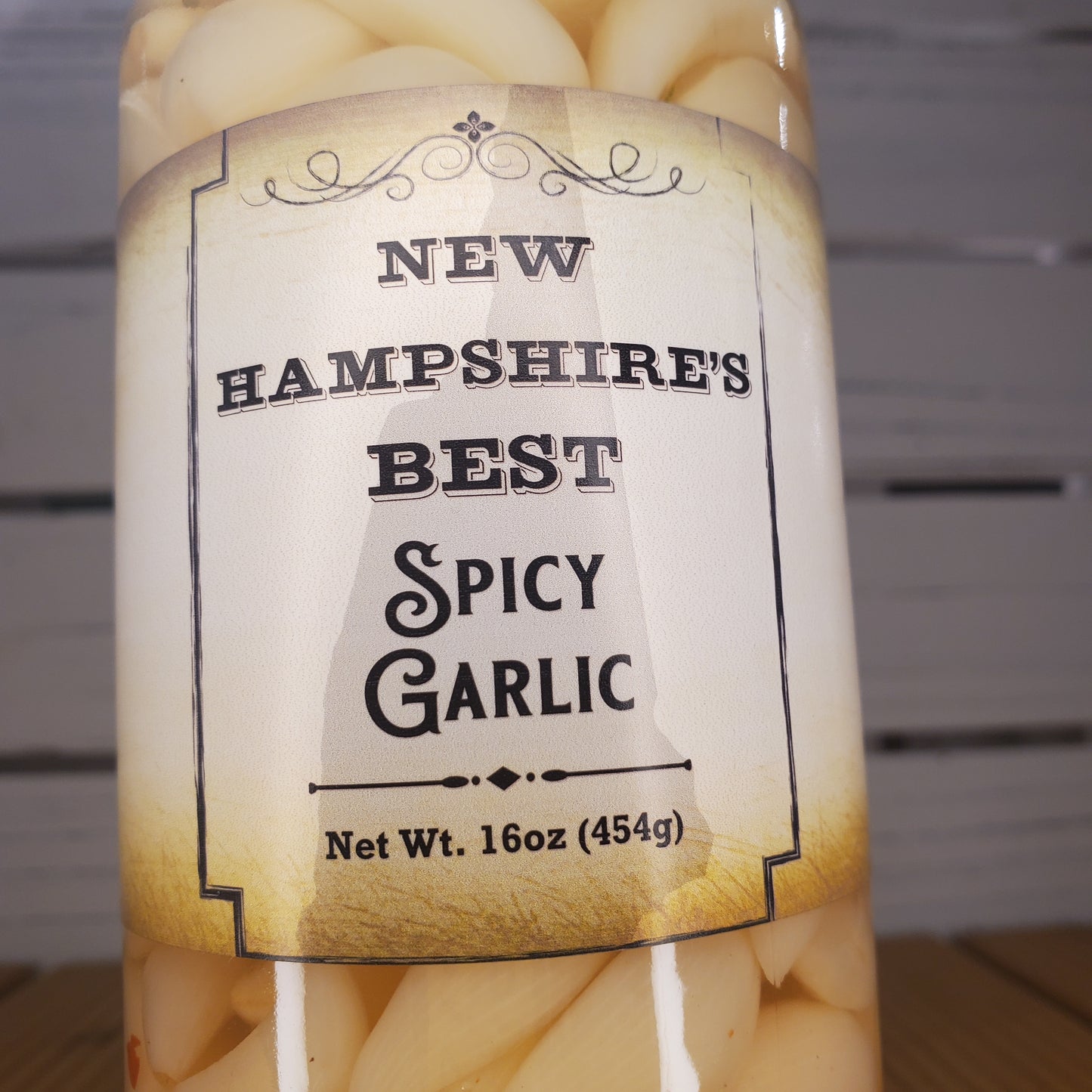 Bottle of New Hampshire's Best Spicy Garlic with a label on a white background