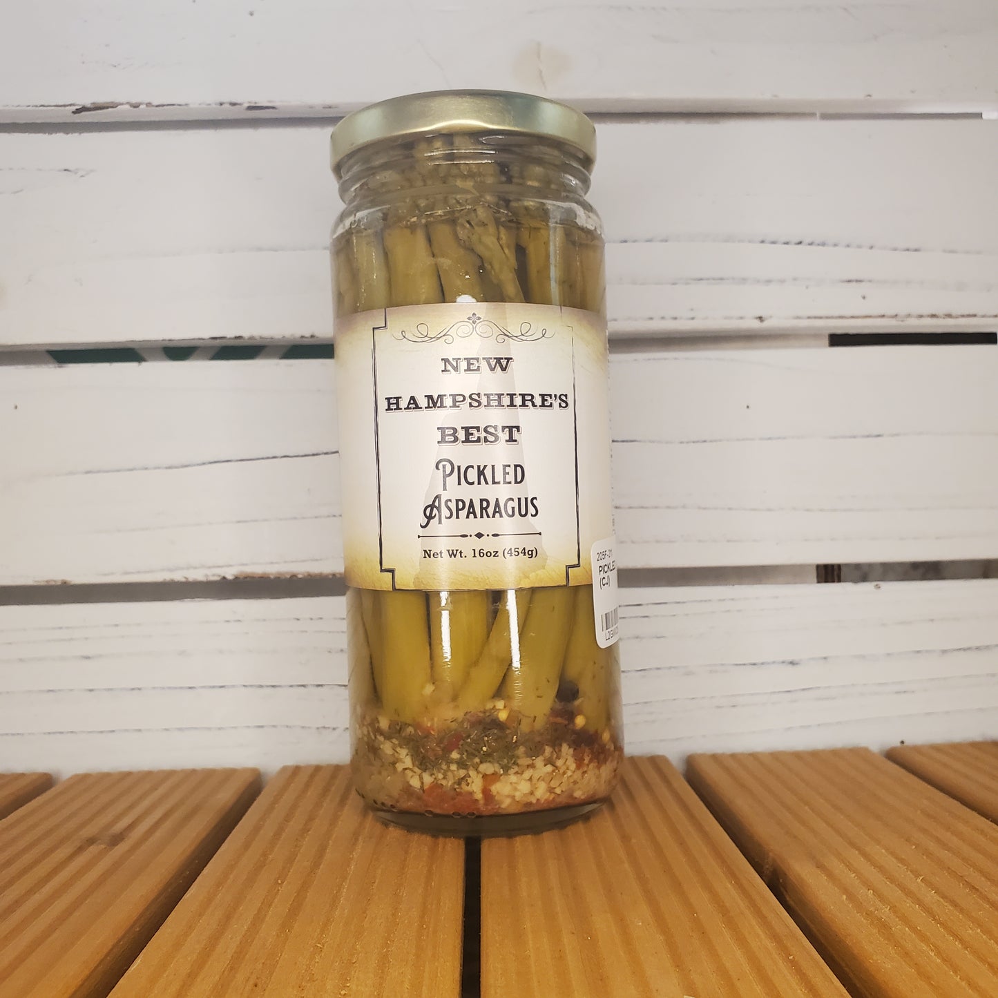 Jar of pickled asparagus with a label on a wooden surface