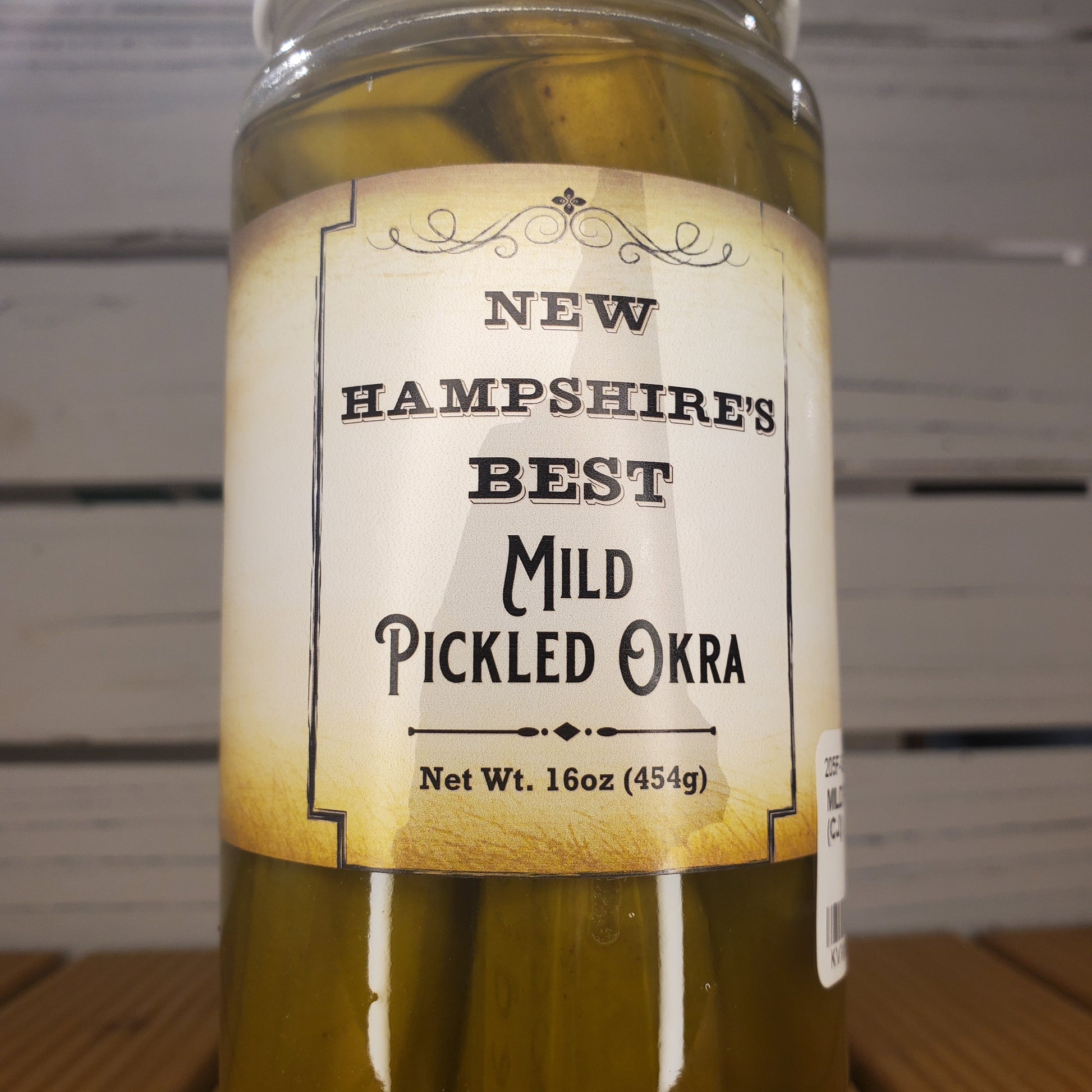 Jar of pickled okra with a label on a white background
