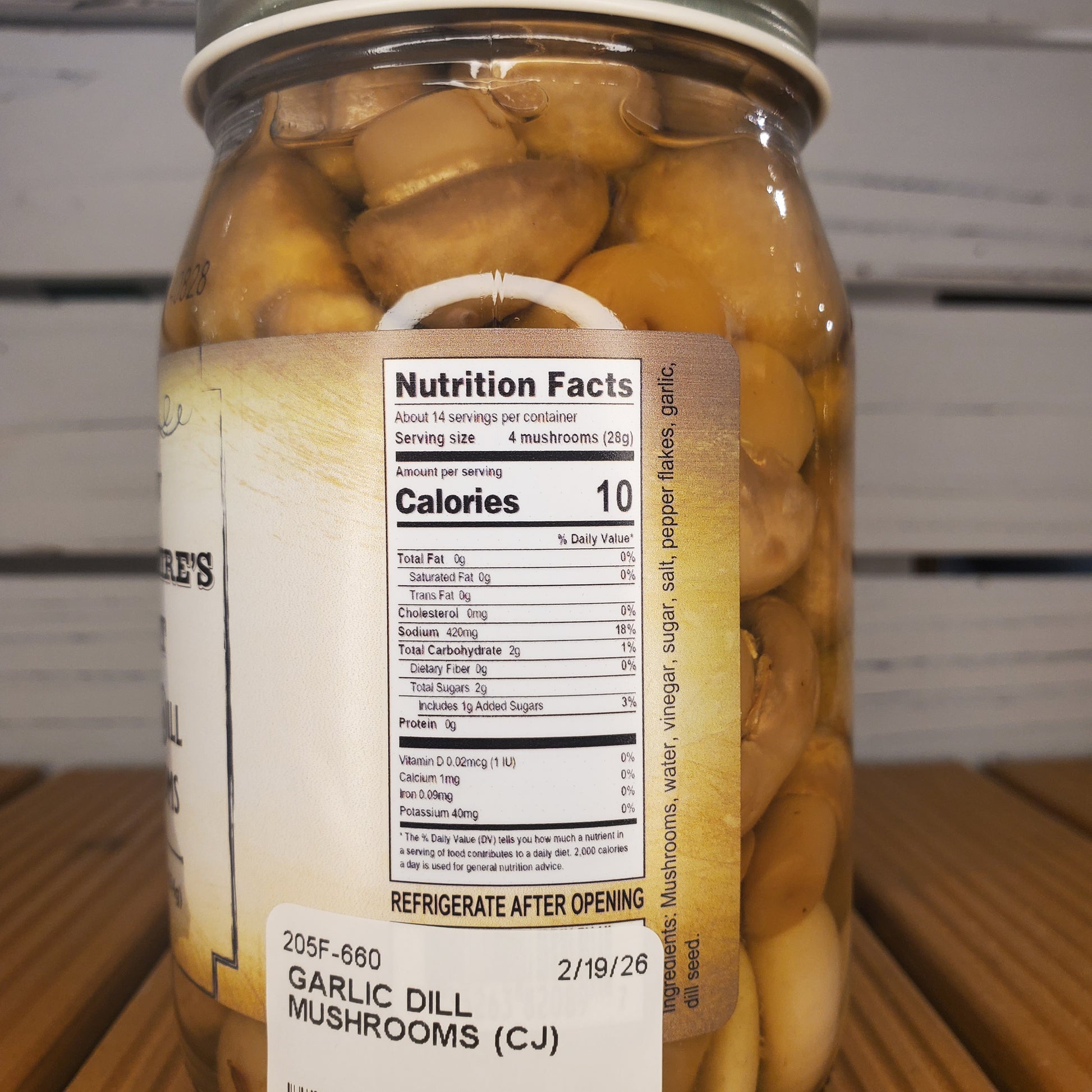 Jar of garlic dill mushrooms with a nutrition label on a white background