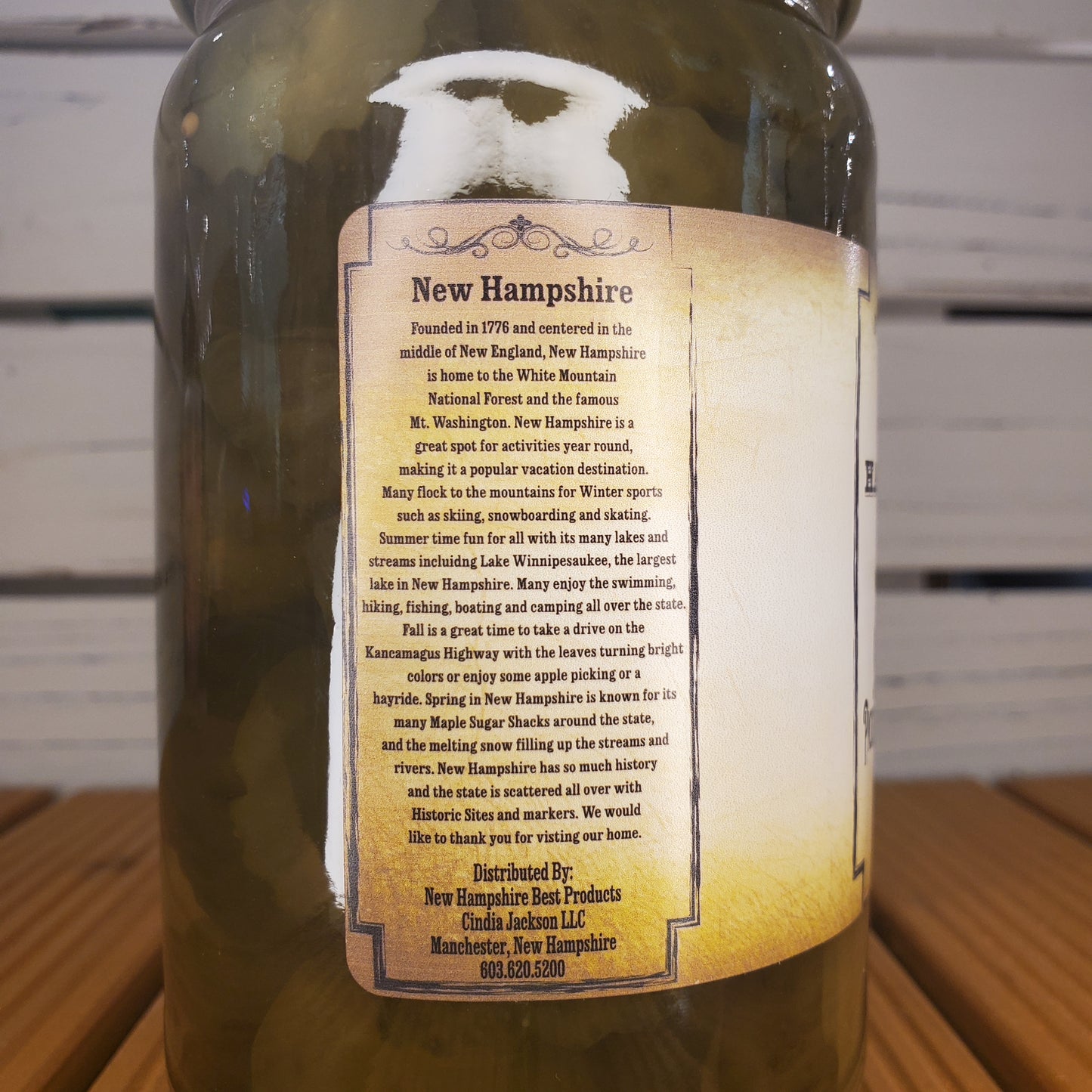 Bottle with a label about New Hampshire on a wooden surface.