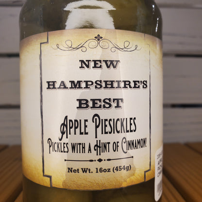 Bottle of New Hampshire's Best Apple Pie Pickles with a label on a wooden surface.