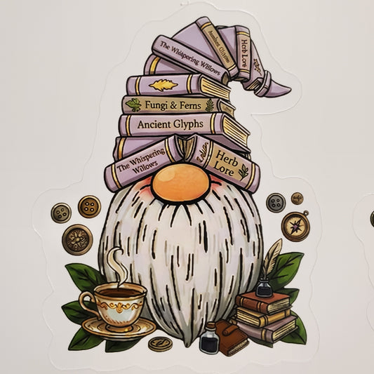 A die-cut sticker featuring a whimsical gnome illustration with a tall hat made of stacked books, a white beard, an orange nose, and surrounding fantasy-themed details like coins, a teacup, leaves, and a quill on a light background.