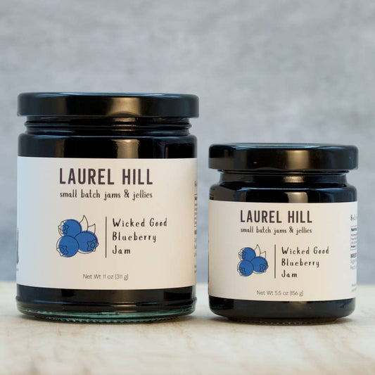 Two jars of Laurel Hill Wicked Good Blueberry Jam on a neutral background