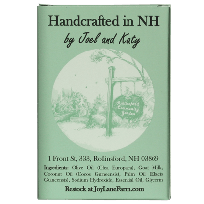 A rectangular mint-green product box with printed text reading 'Handcrafted in NH by Joel and Katy' and 'JoyLaneFarm.com' at the bottom, plus a circular illustration of a garden sign.