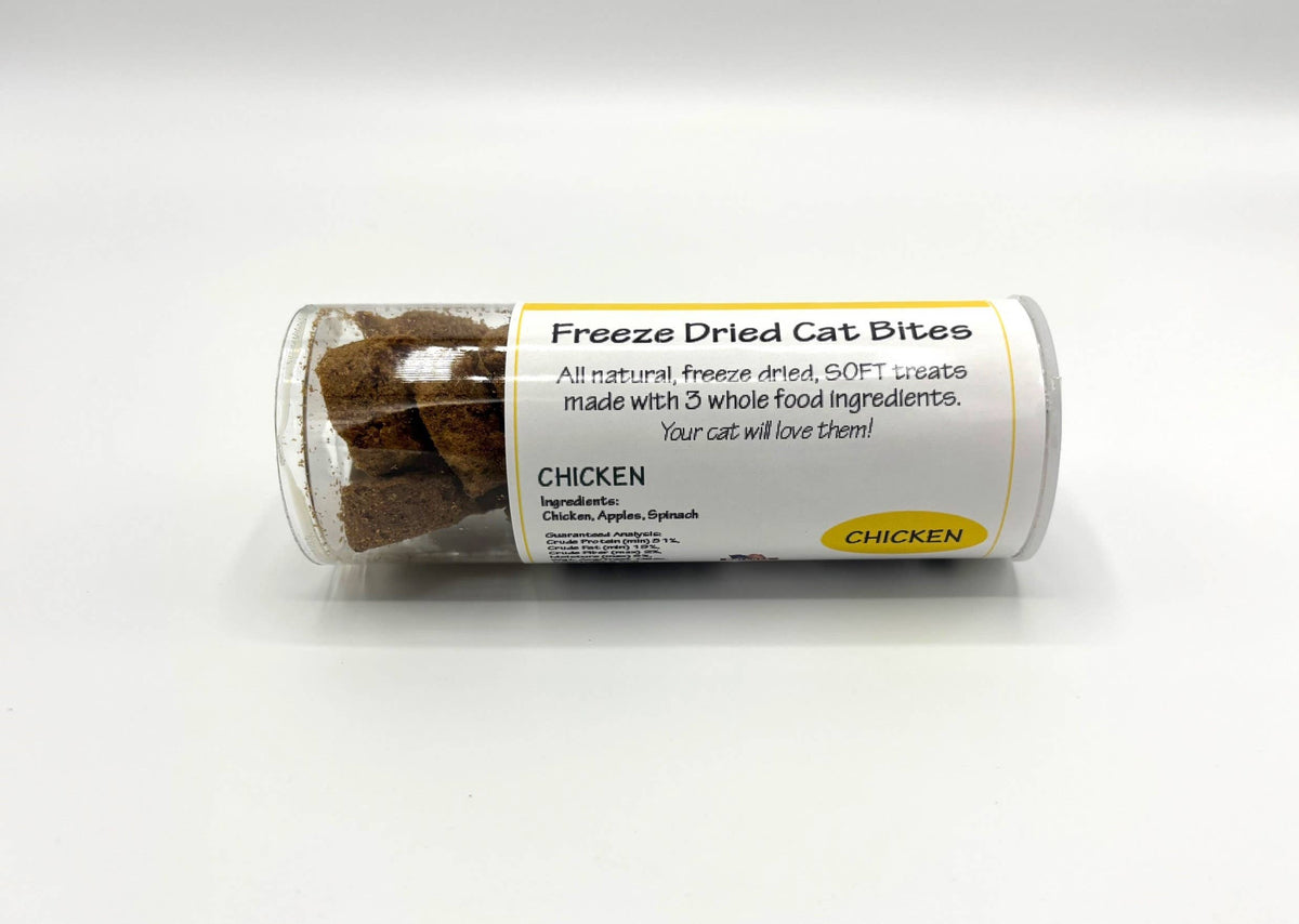 A clear plastic tube of Freeze Dried Cat Bites treats, labeled 'CHICKEN', lying horizontally on a white background.