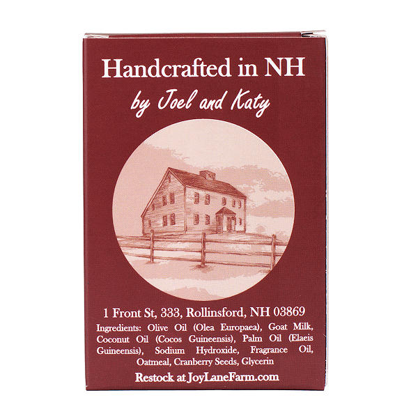 A rectangular product box for Handcrafted in NH by Joel and Katy, featuring a dark red background with white text and a circular illustration of a farmhouse. The box includes ingredient details and the website Restock at JoyLaneFarm.