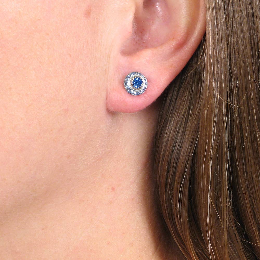 Close-up of an ear wearing a blue gemstone earring.