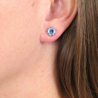 Close-up of an ear wearing a blue gemstone earring.
