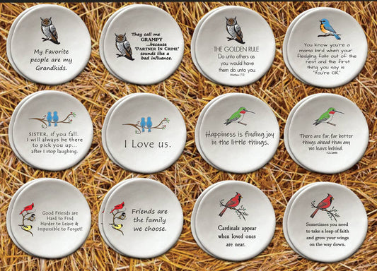 Twelve round ceramic coasters featuring different owl and bird-themed humorous quotes, arranged in a 3x4 grid on a background of golden straw.