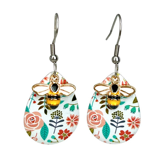 Pair of floral earrings with bee designs on a white background