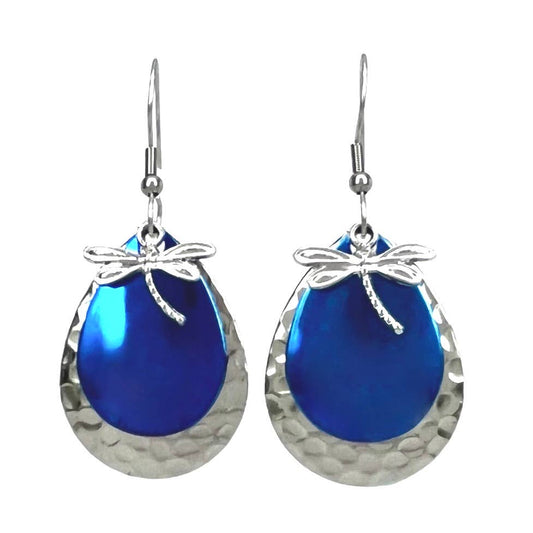 A pair of teardrop-shaped dangle earrings with hammered silver-tone metal frames, vibrant blue iridescent centers, and silver dragonfly charms at the top, shown on a plain white background.