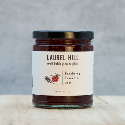 Jar of Laurel Hill Raspberry Lavender Jam on a wooden surface with a gray background